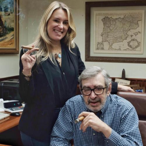 The Story of Cigars NH Cigars father and daughter enjoying cigars indoors.